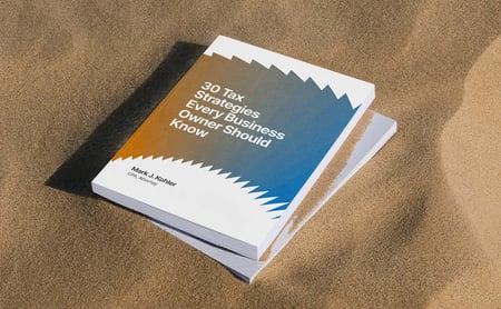  Book titled 30 Tax Strategies Every Business Owner Should Know by Mark J. Kohler resting on sand.