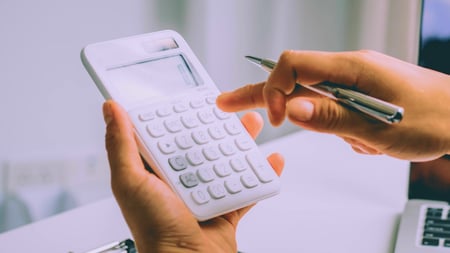  Person holding calculator with a pen